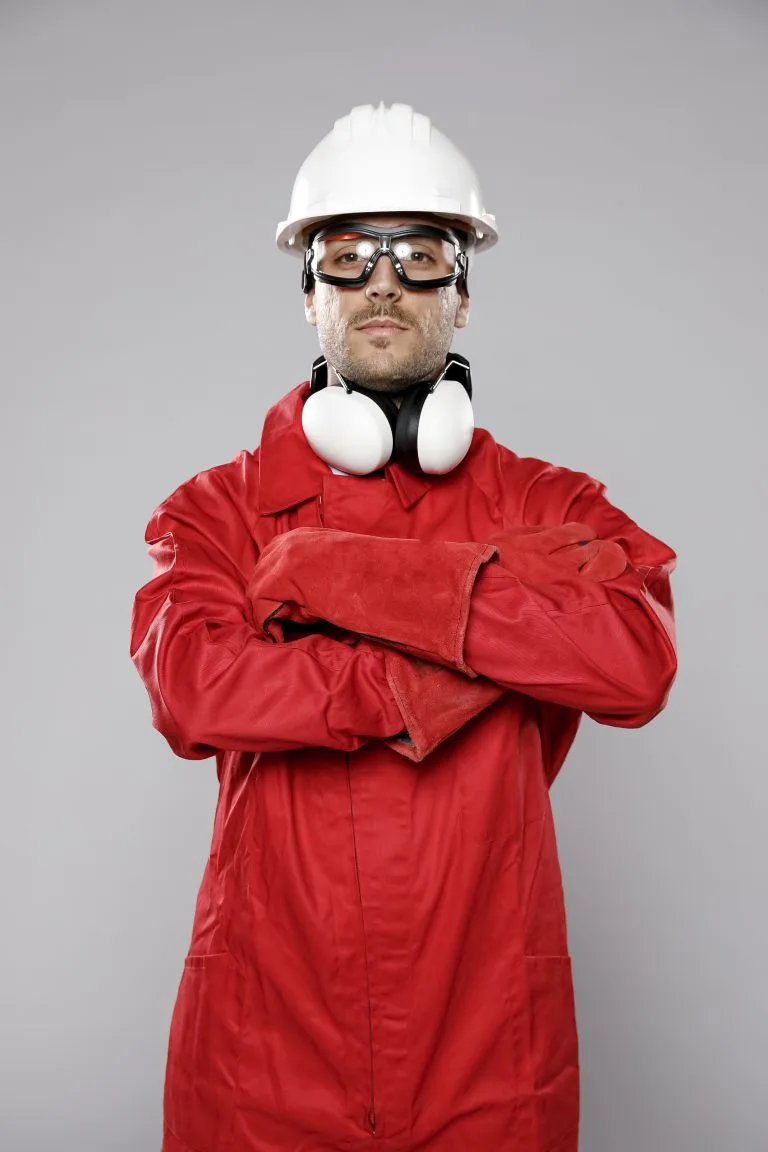 Trabalhador utilizando capacete, oculos, protetor auricular e luvas