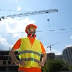Trabalhador de colete e capacete em canteiro de obras